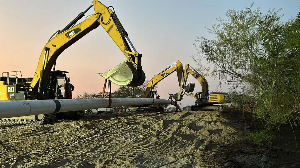 Excavadoras realizando izaje de tubería industrial
