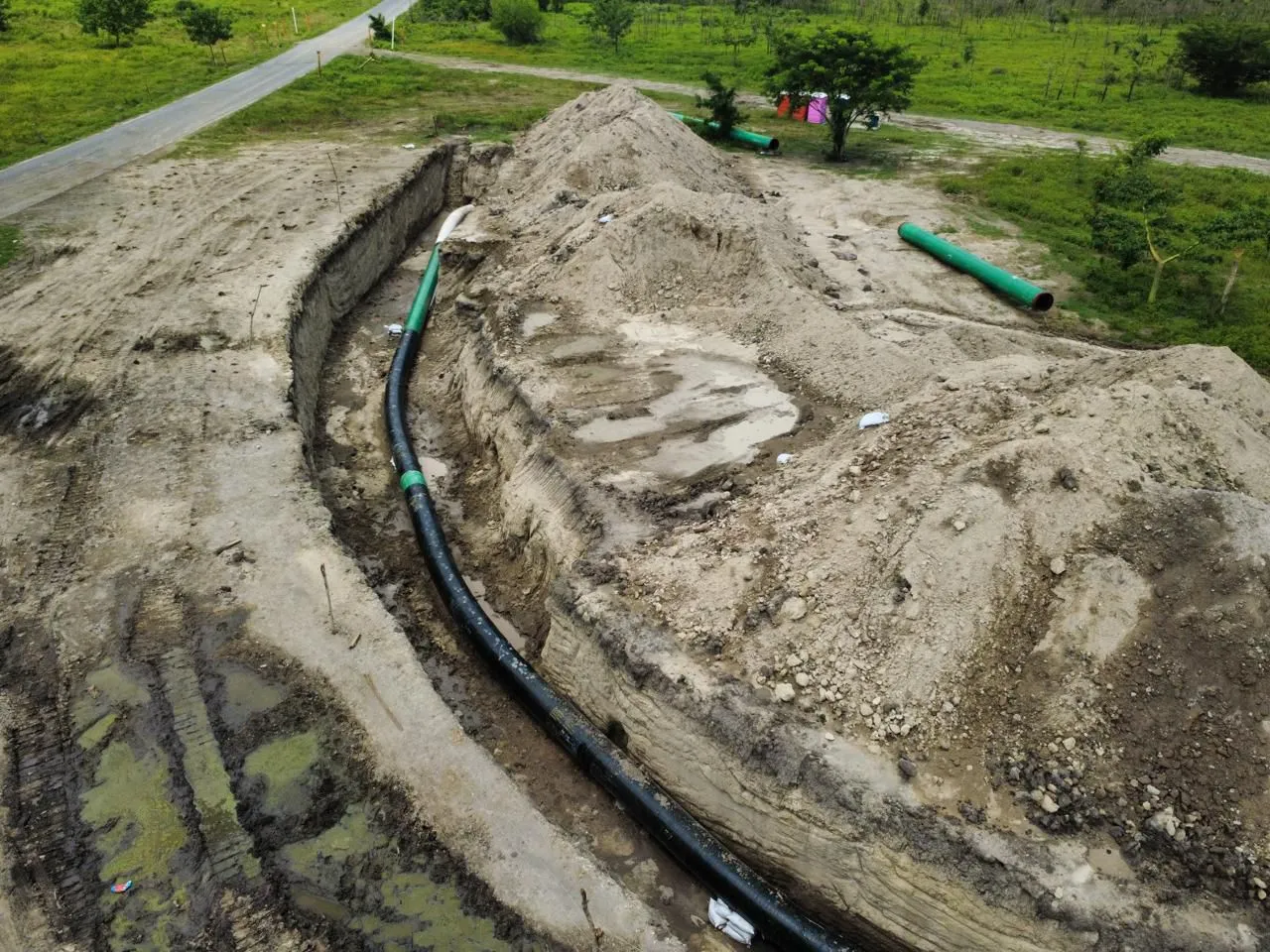 Vista aérea de zanja con tubería revestida lista para tendido